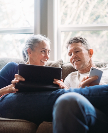 Couple sitting on the sofa looking at tablet